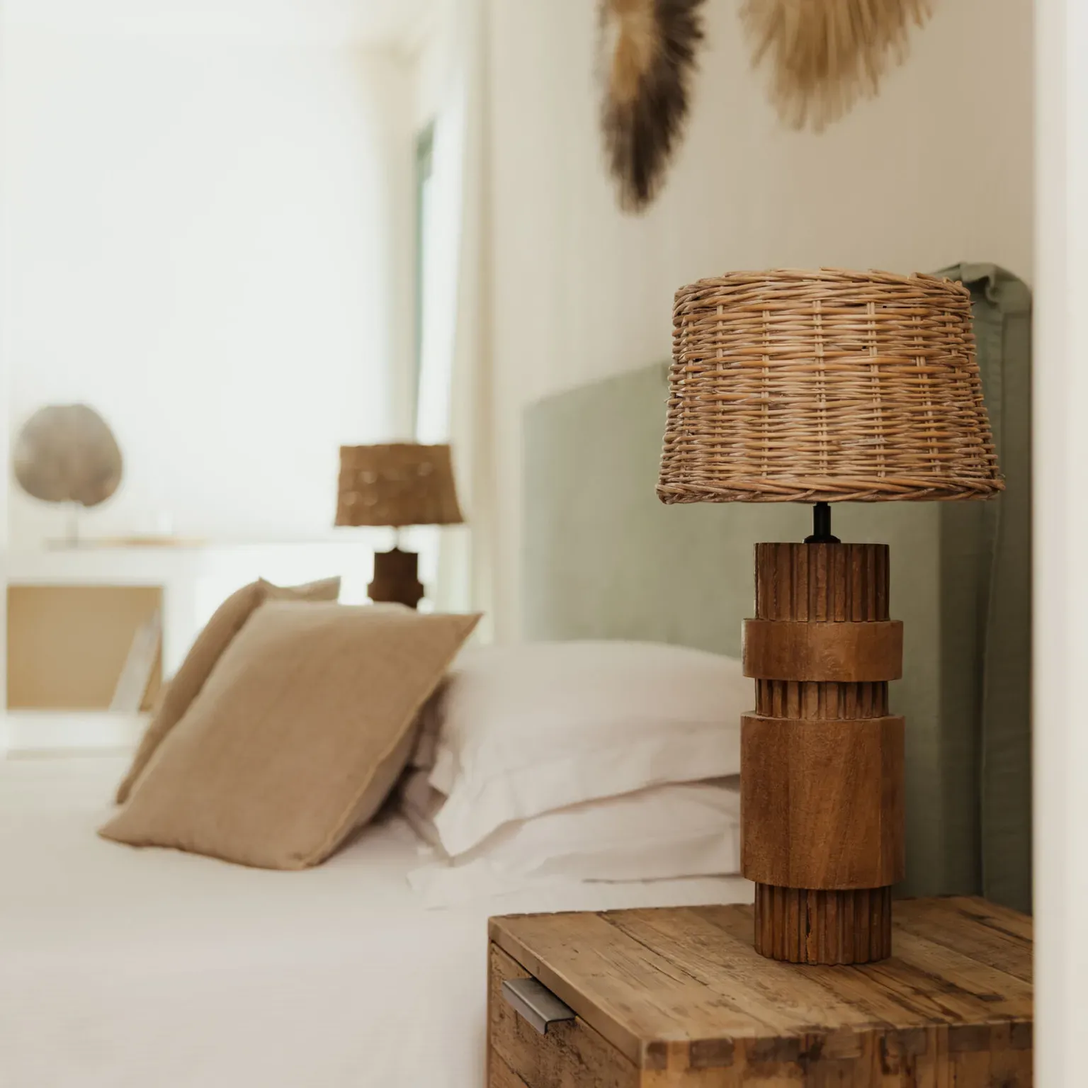 Cozy bedroom with a soft beige bed, wooden side tables, wicker lamps, and woven wall decor, conveying a warm, rustic, and inviting atmosphere.